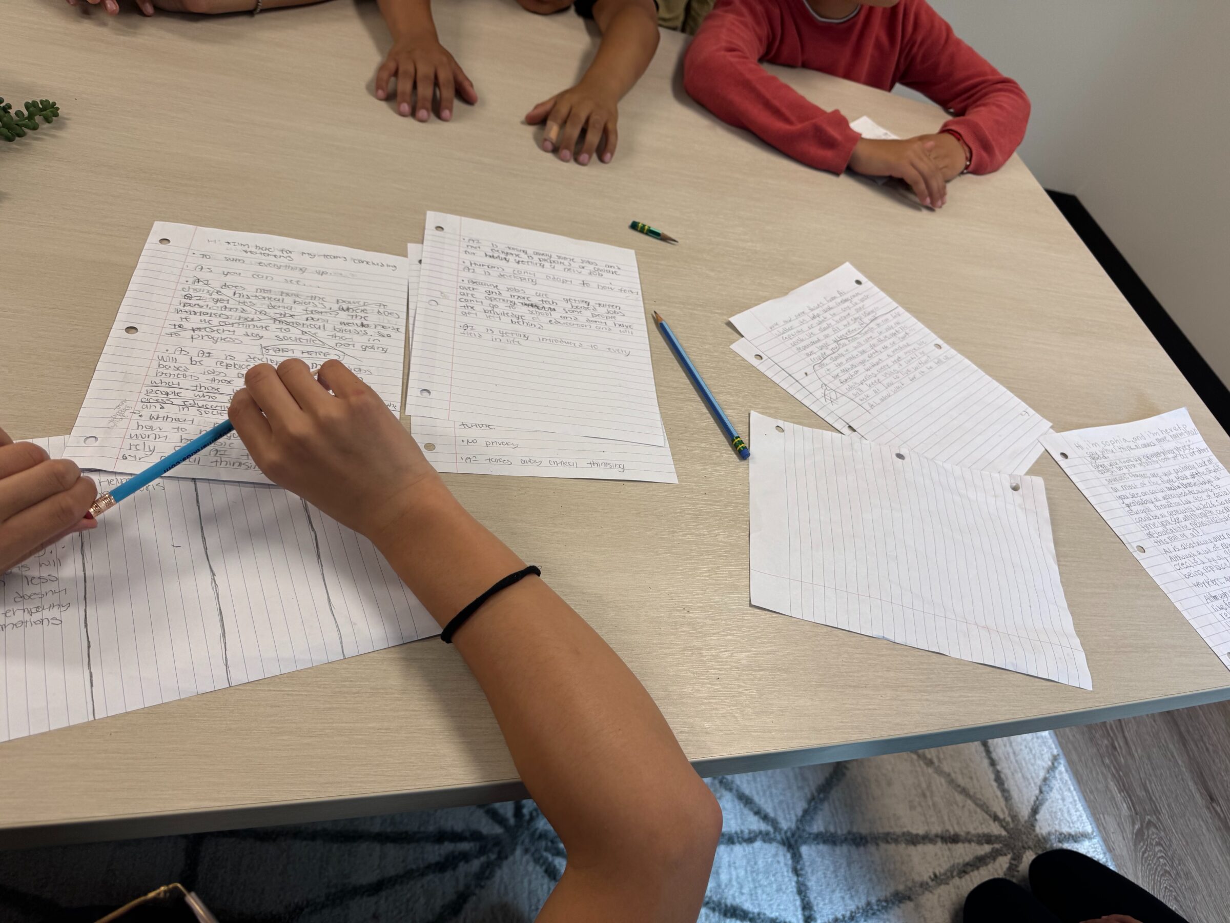 Students writing at a classroom table